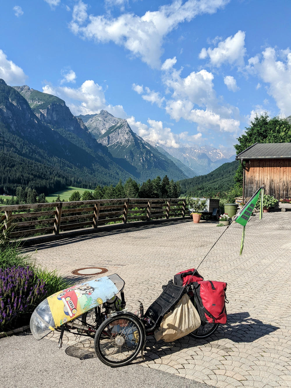 aufgepacktes Liegedreirad steht in den Bergen